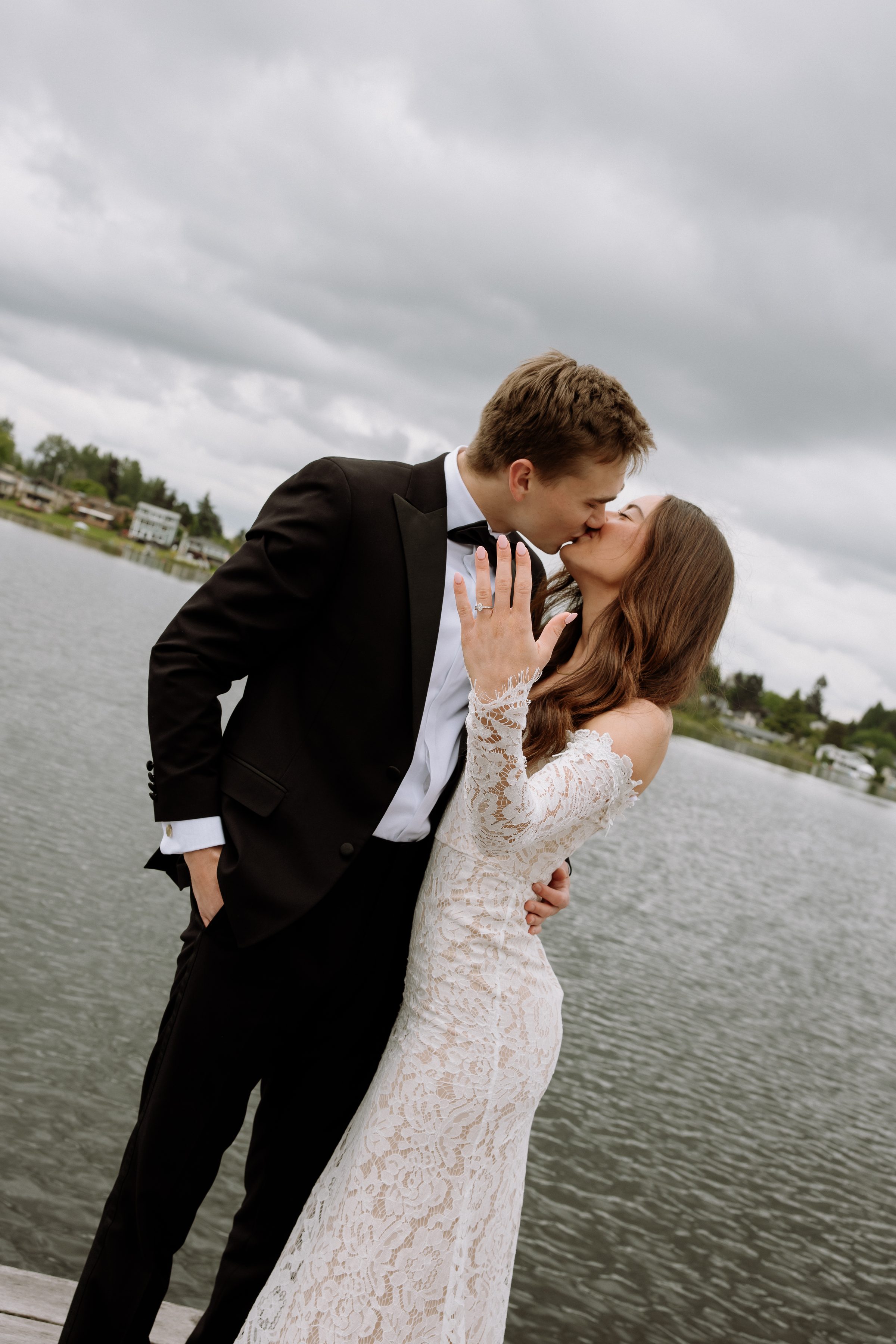 Duncan and Addison kissing on a dock by the lake
