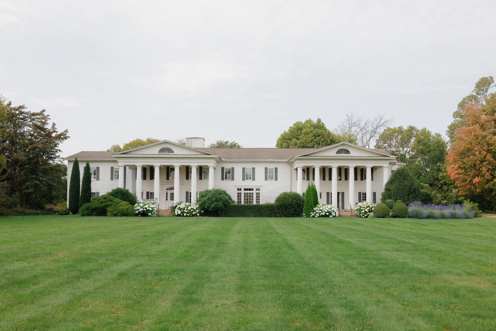 Cedarhurst Mansion, a white colonial-style estate with grand columns and manicured lawns in Cottage Grove, Minnesota